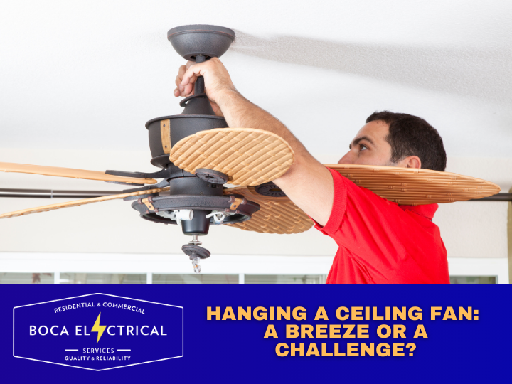 man wearing red shirt installing a ceiling fan