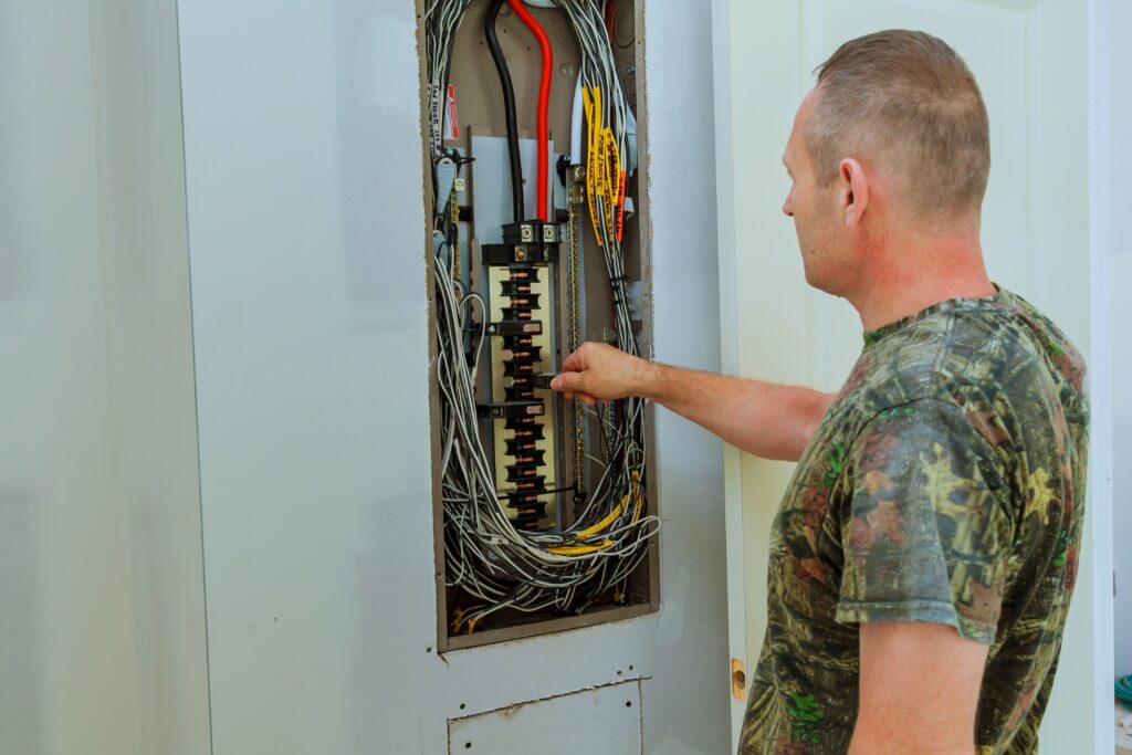 Professional electrician installing components in electrical shield The electrician checks the shield