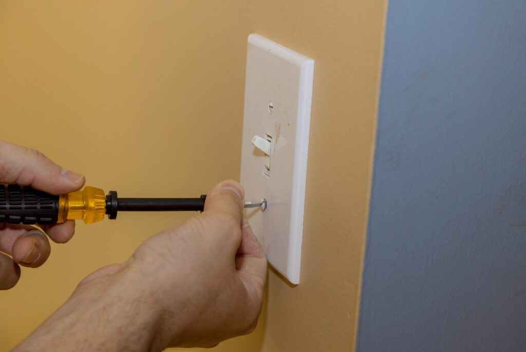 Removing white light switch cover plastic on preparation wall for new paint wall the home renovation