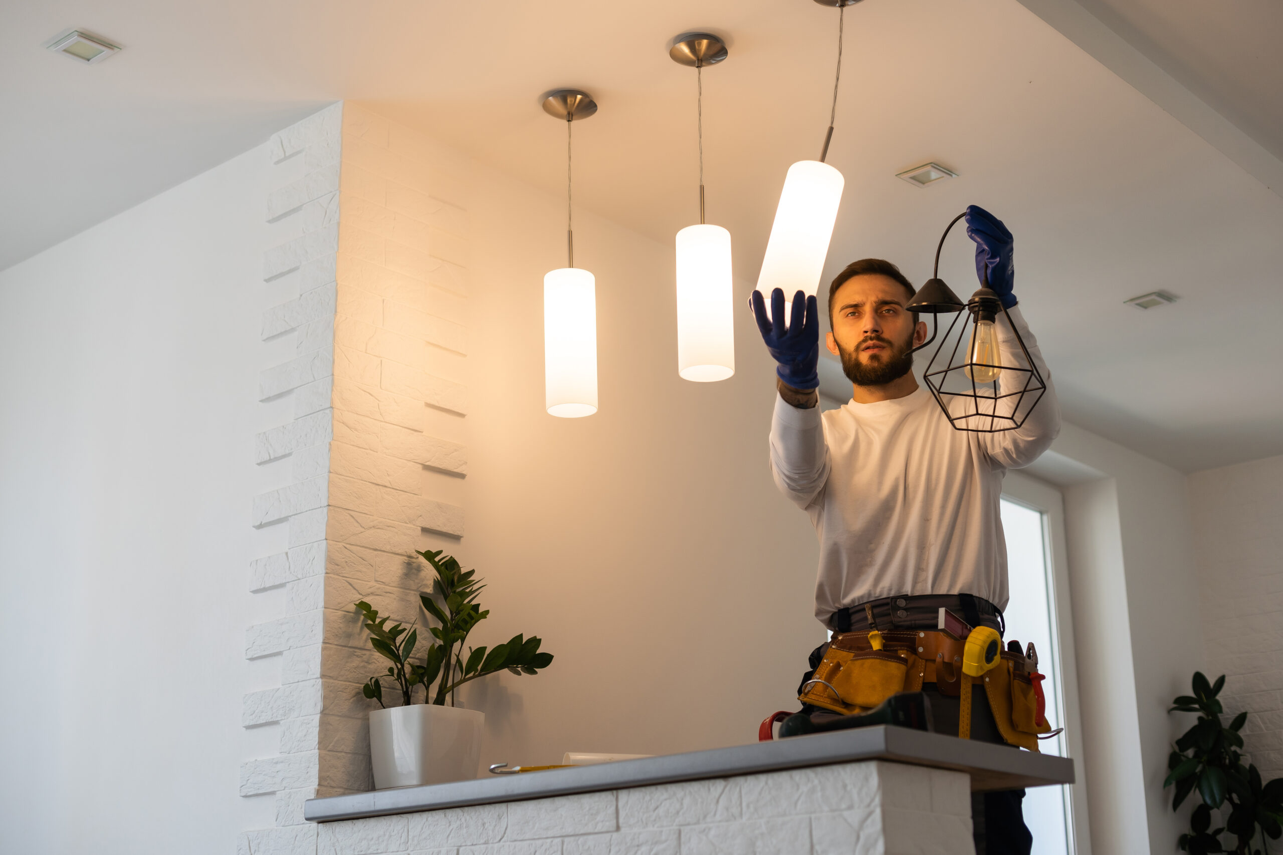 Electrician worker installation electric lamps light inside apartment. Construction decoration concept