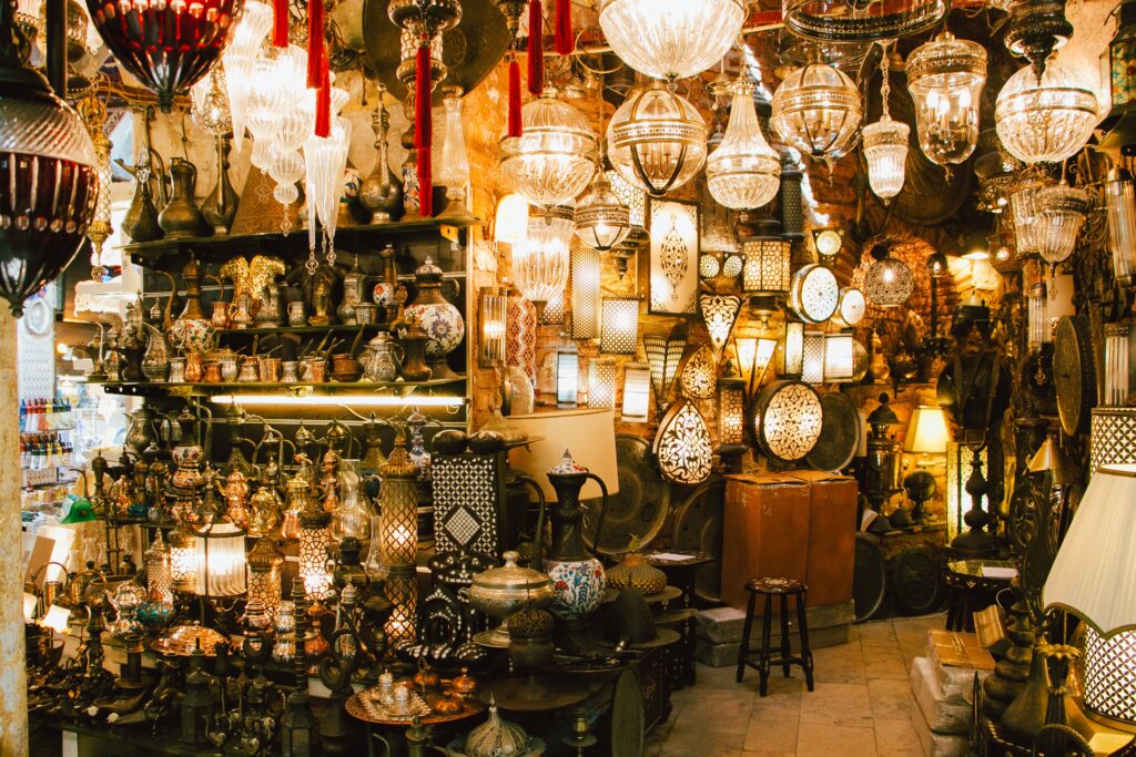 The interior of a chandelier and a lamp antique shop with turned on lamps lot