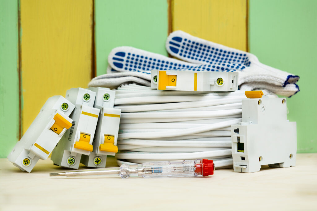 coil wires and circuit breakers with gloves. set of electrician for connecting electricity in the house